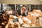 Young woman preparing pastry for sale in supermarket bakery department. Bakery seller.