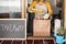 Young woman preparing takeaway organic food inside restaurant during Coronavirus outbreak time - Worker inside kitchen cooking