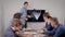 Young woman is presenting report for her colleagues at business meeting in office room, showing data on display