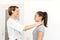 Young woman professional short-haired therapist in a bright medical office, examines a patient, feels the thyroid gland