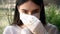 Young woman in protective gloves puts medical mask outside; protection against coronavirus COVID-19