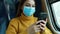 Young woman with protective mask chatting with mobile phone on public transport. Train passenger with surgical mask traveling