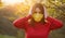 A young woman in a protective medical mask covers her ears from false news with her hands. Massive