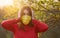 A young woman in a protective medical mask covers her ears from false news with her hands. Massive