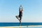 Young woman with protective surgical face mask performing yoga stretching exercises outdoor during covid-19 coronavirus