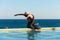 Young woman with protective surgical face mask performing yoga stretching exercises outdoor during covid-19 coronavirus