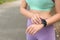 Young woman  pulse with smartwatch after training on street, closeup. Space for text