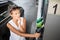 Young woman pumping gas at gas pump
