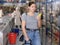 Young woman purchaser choosing cool drink in big supermarket