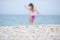 Young woman in purple bikini entering in seawater balancing her hands, focus on foreground