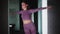 Young woman in purple sports suit doing fitness - standing in the crane pose