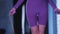 Young woman in purple sports suit jumping over the jumping rope in the gym