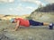 Young woman pushups outdoors in nature.