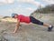 Young woman pushups outdoors in nature.