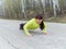 Young woman pushups outdoors in nature.