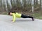 Young woman pushups outdoors in nature.
