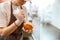 Young woman puts cream inside bun in craft bakery shop