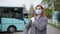 Young woman puts on a medical mask to protect against virus and infection for a city bus ride