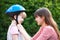 Young Woman Putting Cycle Helmet Onto Girl