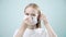 Young woman putting on face medical mask against virus bacteria prevention outbreak on light background. Health protection Corona