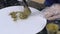 Young woman is putting powder on chocolate figures on table in pastry shop.