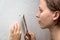 Young woman with a putty knife repairing a wall, renovation at home