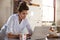 Young woman in pyjamas using laptop at breakfast, close up