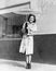 Young woman in a raincoat and umbrella standing in the rain