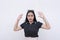 A young woman raises her hands up, surrendering and showing submission. Isolated on a white backdrop