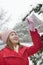 Young woman reaching for a branch in the snow