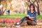 Young woman reading a book in beautiful autumn park