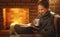 Young woman reading a book by the fireplace on a winter evenin