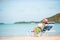 Young woman reading book on sunbed on sandy white beach