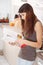 Young woman reading cookbook in the kitchen