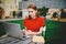 Young woman reading last news on website sitting outdoors at computer