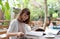 Young woman reading magazine with cofee break in garden on summer day