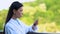 Young woman reading message on smartphone standing hotel balcony outdoors, work