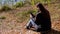 Young Woman Reading Text Message in a Smartphone, Sitting on Fallen Dry Leaves