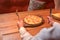 Young woman ready to eat ajarian khachapuri with cheese on wooden board in a restaurant. Still life, eating out concept.
