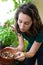 Young woman realizing her plant is dead on her city garden balconny - Nature and environment theme