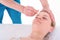 Young Woman receives facial cupping massage facial rejuvenation treatment at acupuncture wellness spa