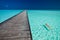 Young woman in red bikini swimming next to jetty in azure water