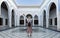 Young woman with red dress and hat visiting typical Moroccan architecture in Marrakesh. Morocco - Travel and vacation lifestyle