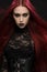 Young woman with red hair in black gothic costume