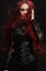 Young woman with red hair in black gothic costume