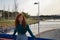 Young woman with red hair, freckles, leaning on a railing and smiling in an outdoor park. Concept happiness, smile, laughter, joy