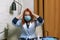 Young woman with red hair in medical mask holds her head in shock upon learning of positive test for covid-19