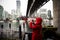 Young Woman in Red Hooded Coat taking picture of scenery in Vancouver`s False Creek Water Inlet on a Rainy Day