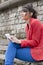 Young woman in red jacket with tablet