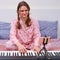 Young woman in a red pajamas looks at the phone on a tripod plays music on the home piano